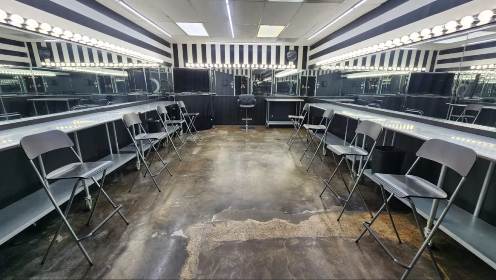 A look inside the Polished hair and makeup studio. The walls are lined with mirrors and Hollywood lights.