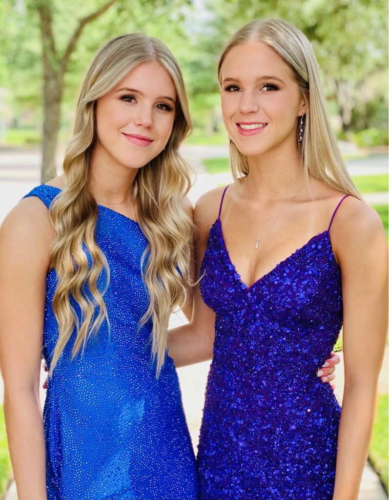 Photo of twin sisters in their blue prom dresses after our hair and makeup appointment
